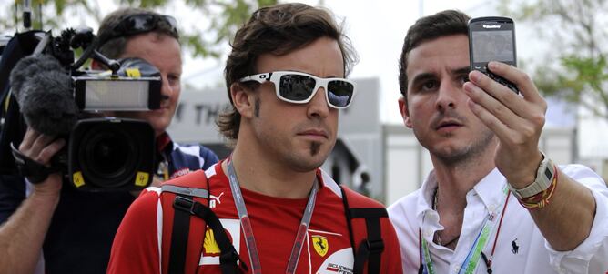 El piloto español de Fórmula Uno Fernando Alonso, de la escudería Ferrari, se toma una fotografía con un fan durante la tercera sesión de entrenamientos en el circuito de Sepang a las afueras de Kuala Lumpur (Malasia) hoy, sábado, 24 de marzo de 2012. El 