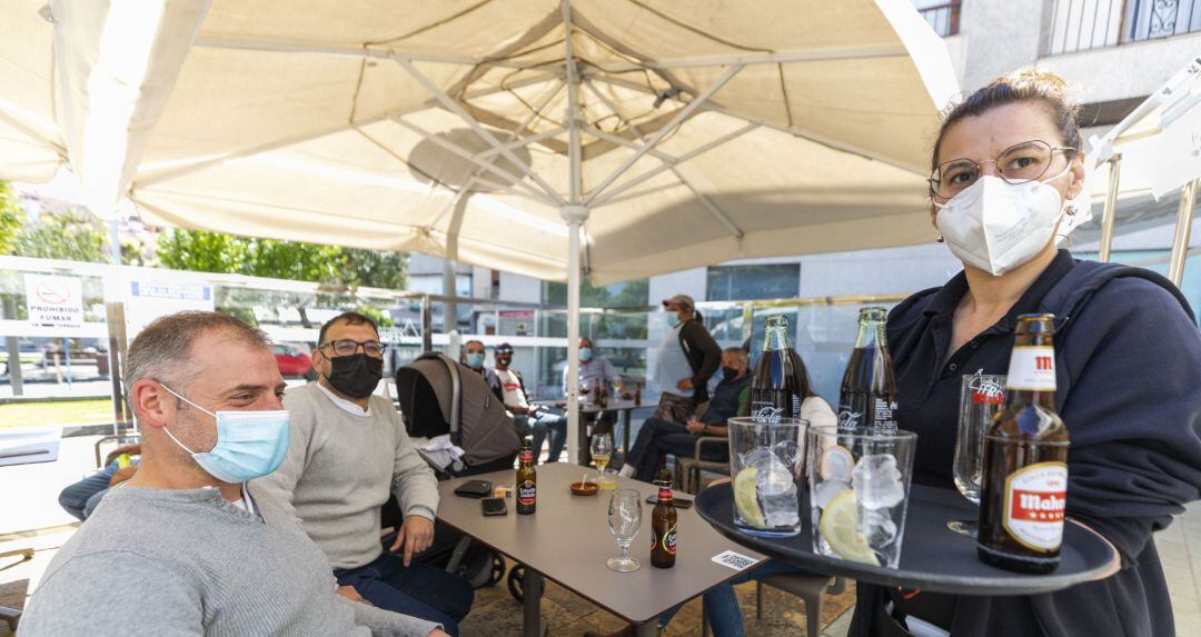 Una camarera sirve en una terraza.