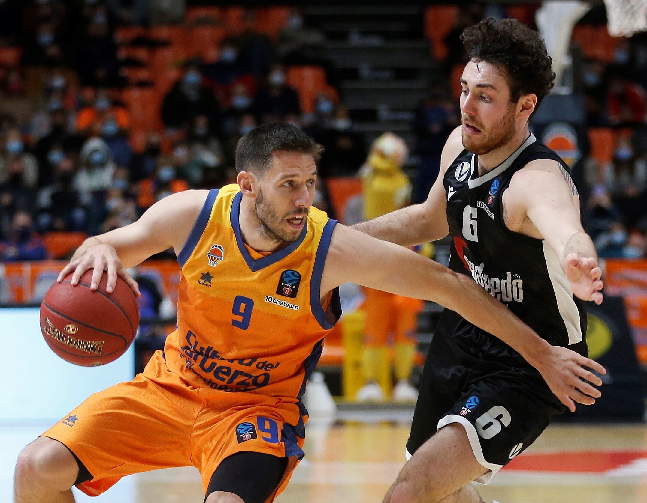 El base belga del Valencia Basket Sam Van Rossom intenta superar al base de la Virtus de Bolonia Alessandro Pajola en partido correspondiente a la jornada 13 de la Eurocup disputado hoy miércoles en el pabellón Fuente de San Luis, en Valencia. EFE / Miguel Ángel Polo.