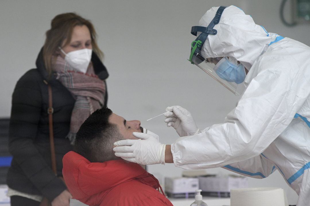 Un hombre se somete a un test de antígenos en un dispositivo de cribado masivo, en una imagen de archivo