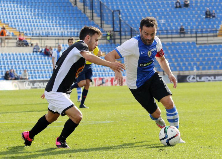 Paco Peña, jugador del Hércules CF, intenta superar a un jugador del Llosetense