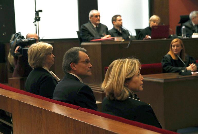 El expresidente catalán Artur Mas, junto a las exconselleras Joana Ortega (i) e Irene Rigau (d), en la sala del Tribunal Superior de Justicia de Cataluña donde serán juzgados por los delitos de desobediencia grave y prevaricación al mantener la consulta d