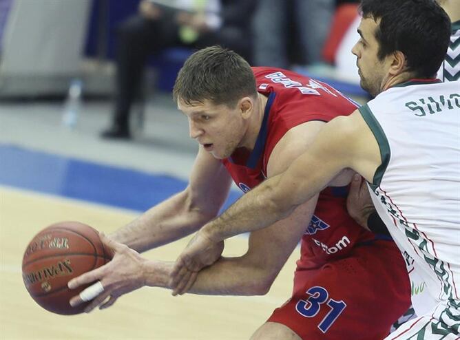 El jugador del CSKA Moscú, Viktor Khryapa (i), lucha por el balón con Krunoslav Simon, del Unicaja, durante el partido de Euroliga que ambos equipos han disputado en Moscú