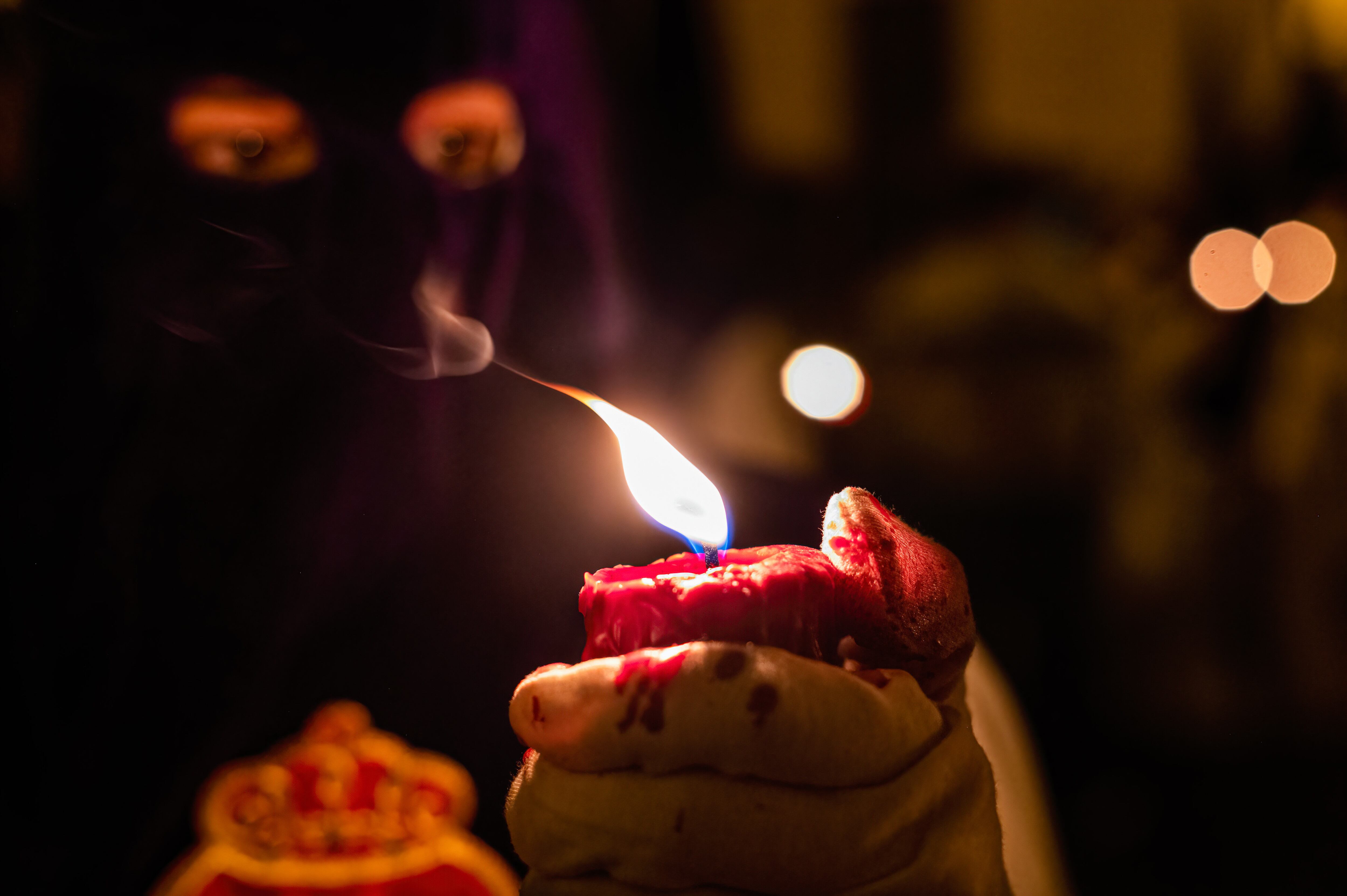 SEVILLE, SPAIN - 2022/04/15: A penitent holds a lit candle during the Holy Week midnight procession, known as the Madruga, in Seville. After two years of Covid-19 travel restrictions and cancellation of social activities in Spain, they finally resumed their activities celebrating the Holy Week. (Photo by Miguel Candela/SOPA Images/LightRocket via Getty Images)