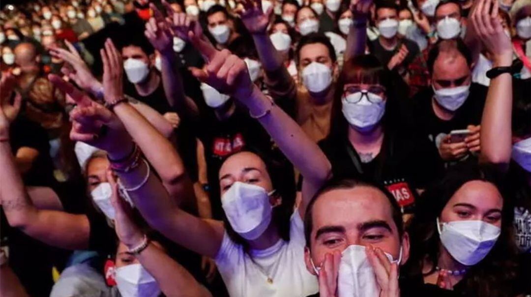 Un grupo de jóvenes con mascarilla en un evento multitudinario