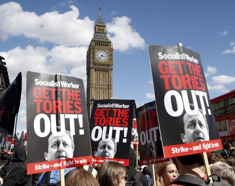 Protesters hold placards during a protest against the Conservative Party in central London, May 9, 2015.  REUTERS/Phil Noble 