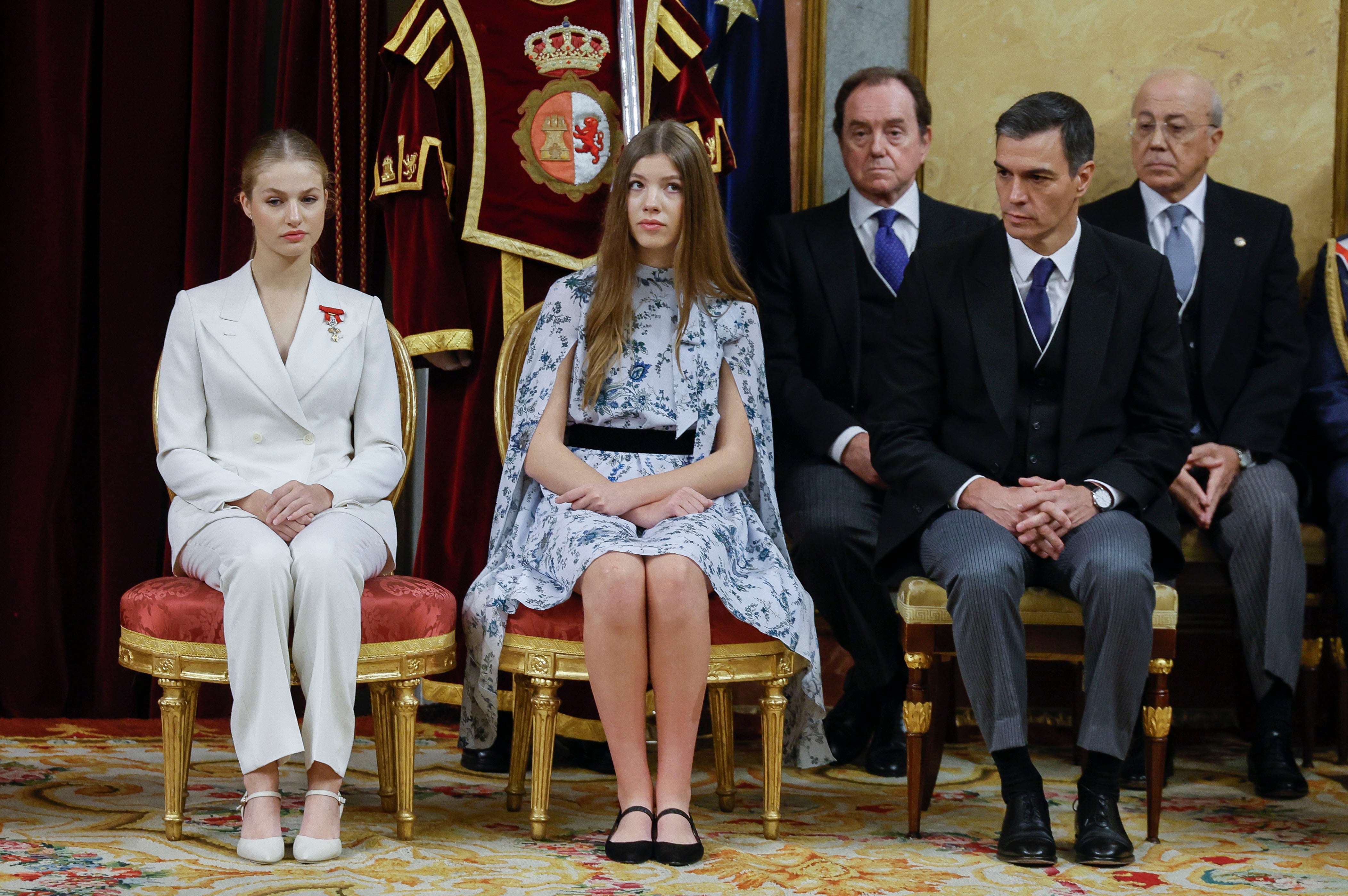 La princesa Leonor (i), sentada junto a su hermana, la infanta Sofía (c), y el presidente del Gobierno, Pedro Sánchez (d).