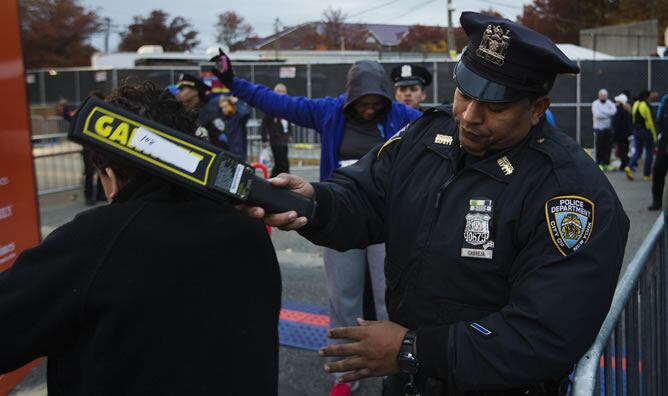 Un policía pasa un detector de metales a uno de los corredores del maratón de Nueva York.