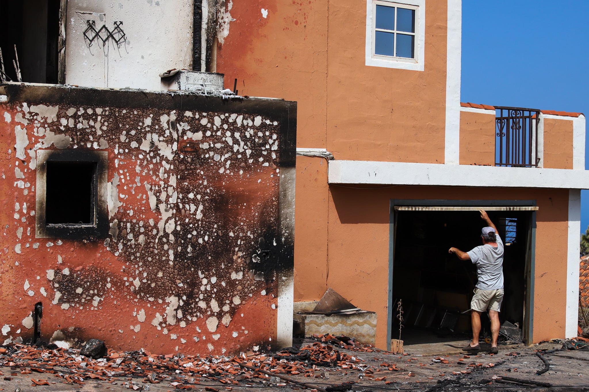 GRAFCAN4225. PUNTAGORDA (LA PALMA), 18/07/2023.- Los medios de extinción del incendio que se declaró en el noroeste de La Palma en la madrugada del sábado se concentran este martes en el Parque Nacional de la Caldera de Taburiente, en una zona de pinar de orografía complicada y difícil acceso, pero se confía en que pueda haber &quot;una mejora sustancial&quot; en la evolución del fuego en las próximas horas. Los otros dos frentes del incendio, el norte y el sur, están perimetrados, de manera que el operativo de extinción ha empezado a tratar la parte que afecta al Parque Nacional, unas 200 hectáreas de las aproximadamente 3.500 afectadas, como un incendio separado. En la imagen, un vecino de Puntagorda junto a su vivienda quemada por el incendio. EFE/ Luis G Morera
