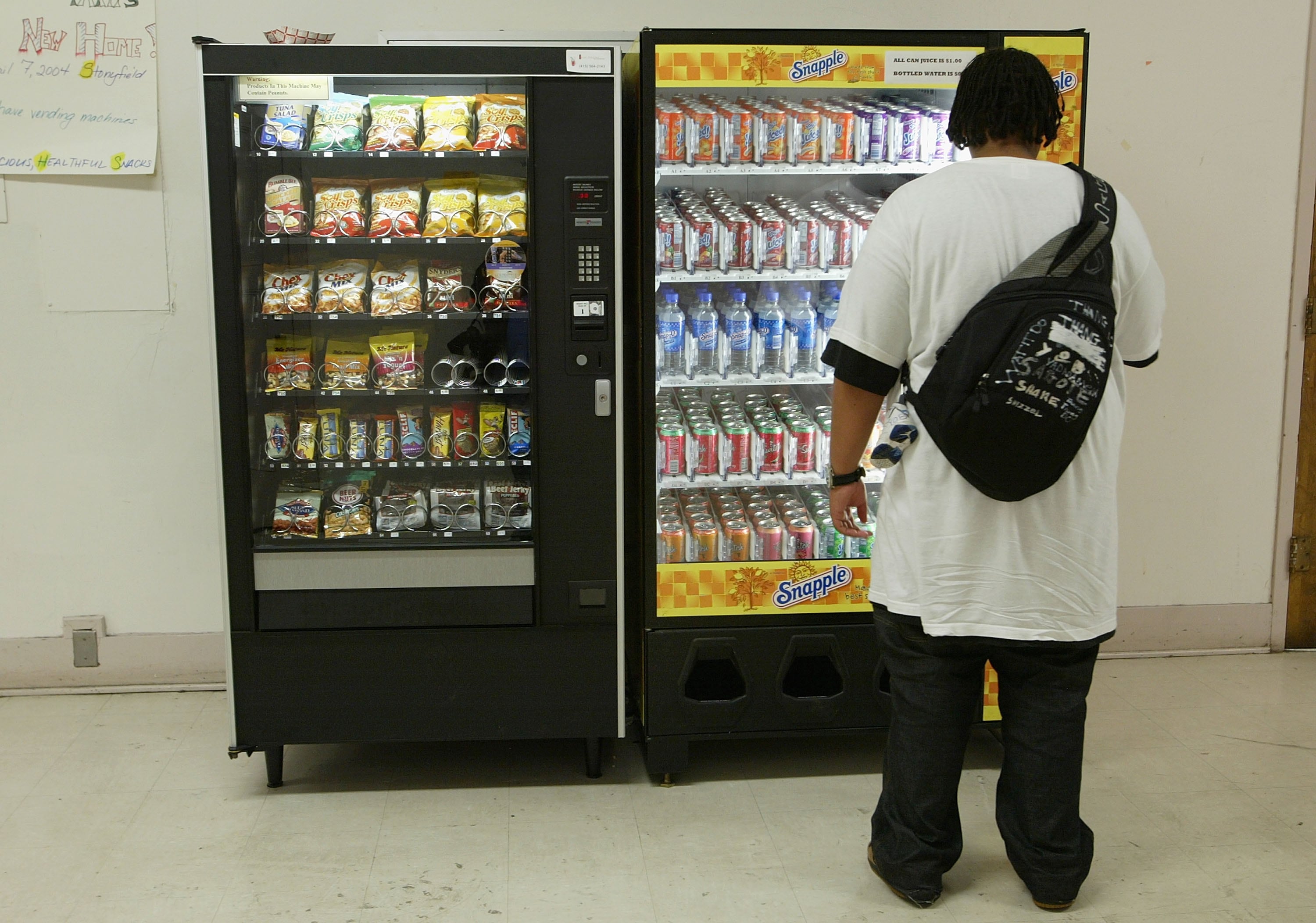 Joven frente a una máquina de vending