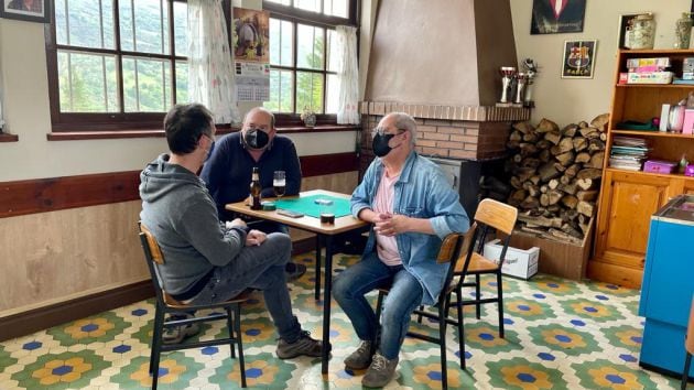 Paco y Joaquín contando su historia en el bar de las escuelas de Ovín donde se juntan a menudo a jugar a las cartas