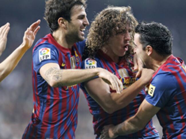 Los jugadores del F. C. Barcelona, Cesc Fábregas, Carles Puyol y Xavi Hernández, celebran el primer gol del equipo blaugrana, durante el encuentro correspondiente a la ida de los cuartos de final de la Copa del Rey, que les enfrenta esta noche al Real Mad