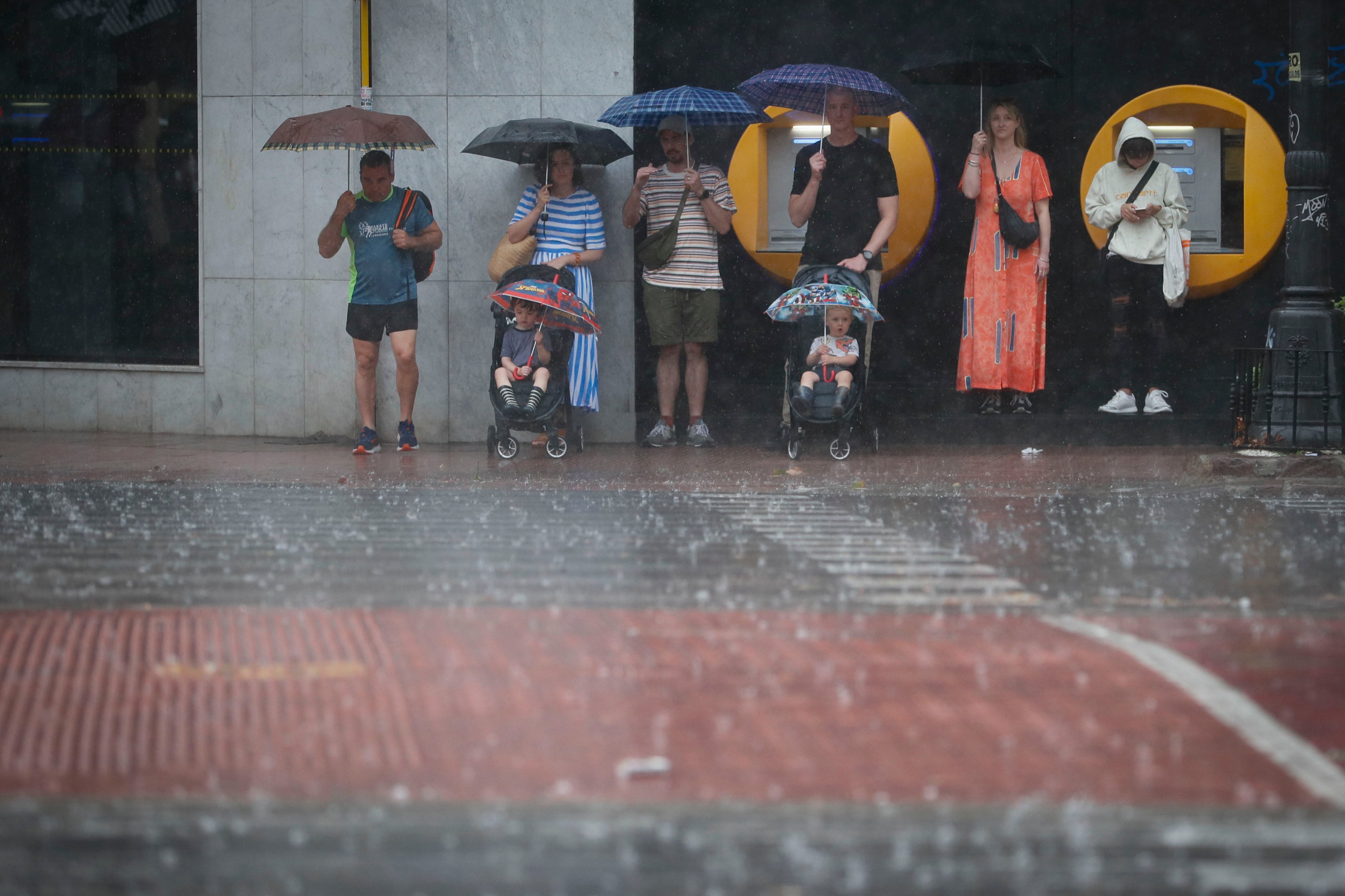 Personas refugiadas de la lluvia. EFE/ Juan Carlos Cárdenas