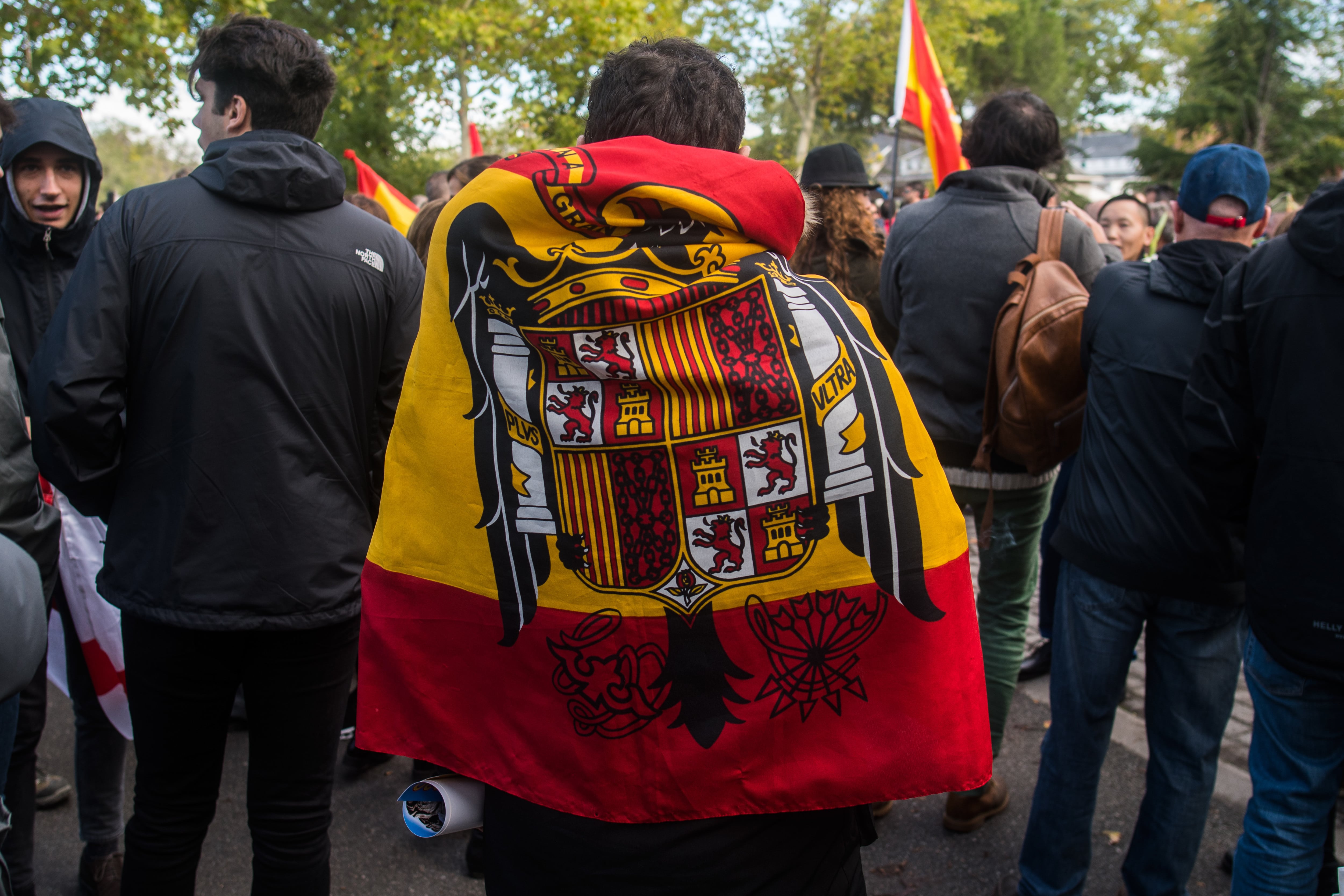 Un simpatizante del dictador Francisco Franco luce una bandera de la época preconstitucional durante una protesta cerca del cementerio de Mingorrubio.