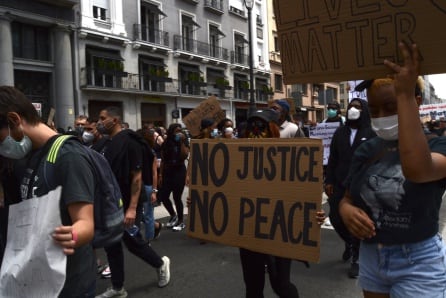 Mujeres levantan pancartas con los mensajes de &quot;No justice, no peace&quot; y &quot;Black lives matter&quot; en la calle Alcalá.