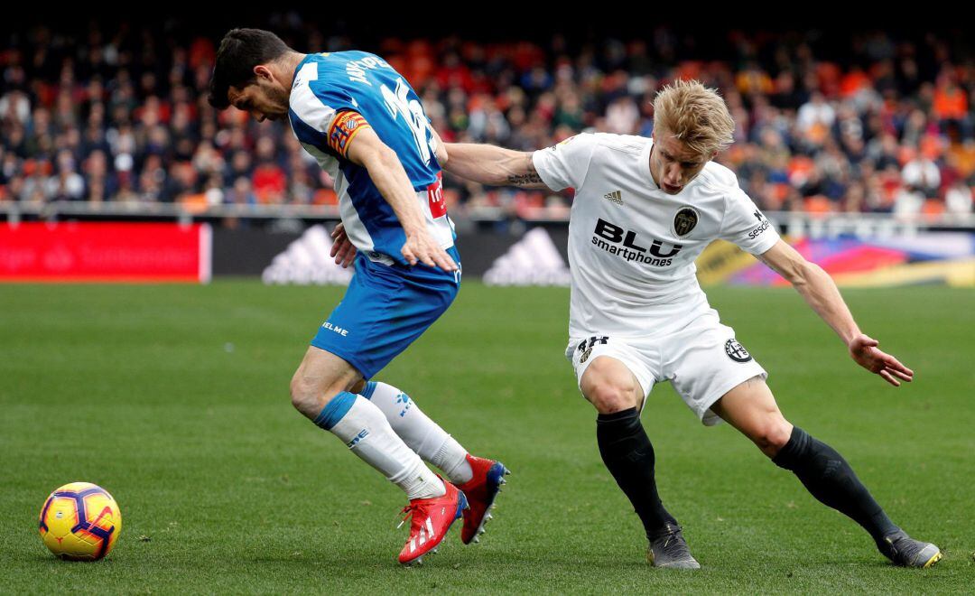 GRAF9051. VALENCIA, El centrocampista danés del Valencia CF, Daniel Wass (d), lucha el balón ante el defensa del RCD Espanyol, Javier López (i), durante el partido correspondiente a la jornada 24 de la Liga Santander, disputado hoy en el estadio de Mestalla, en Valencia. EFE, Juan Carlos Cárdenas