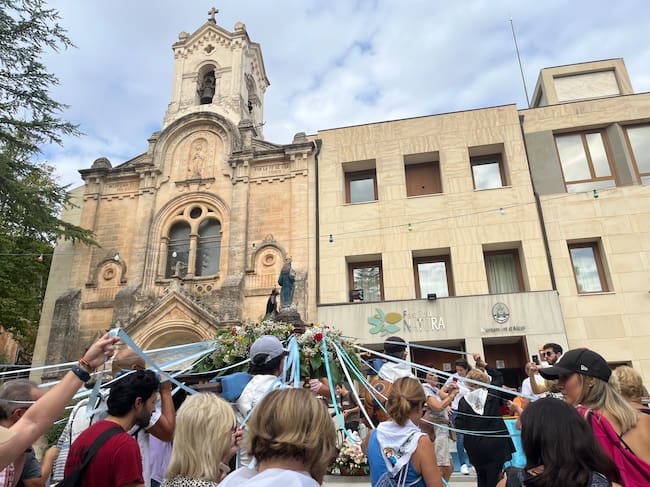 Los portadores y portadores pasando por delante del Santuario con la imagen peregrina de la Mare de Déu dels Lliris.