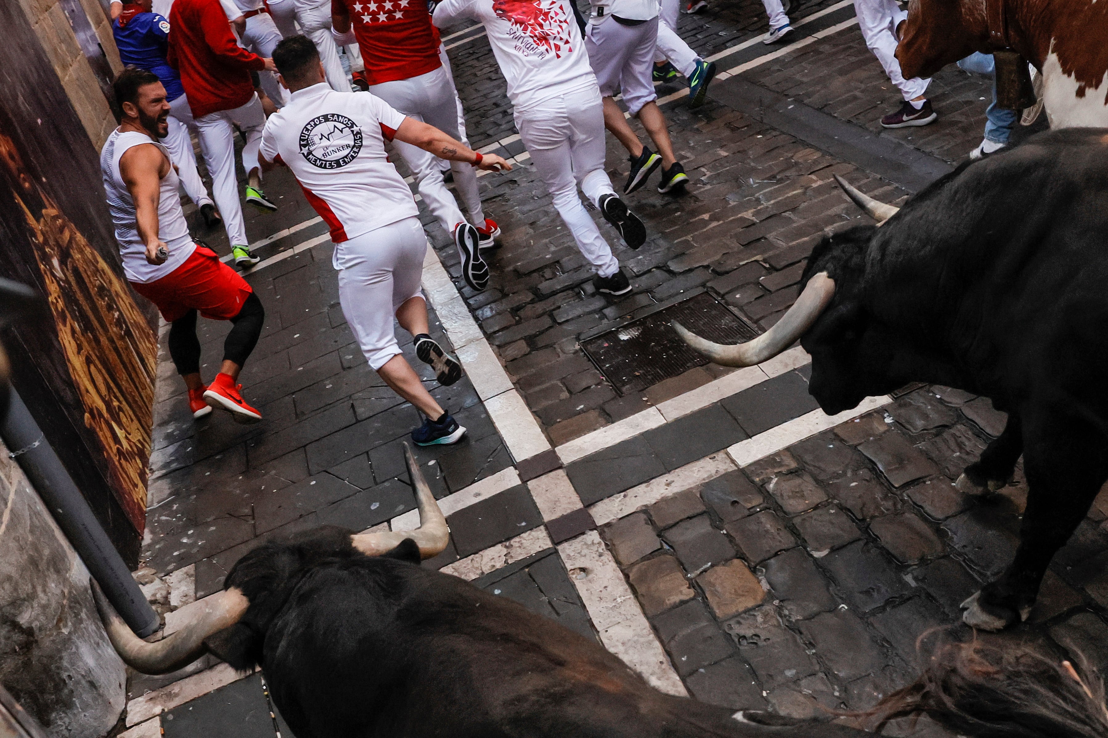 Los mozos, durante el cuarto encierro de los Sanfermines con toros de la ganadería La Palmosilla este domingo en Pamplona