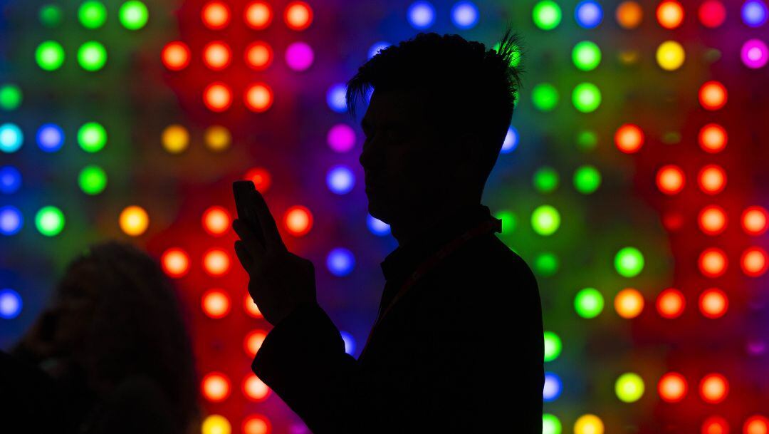 Un hombre junto a su teléfono móvil durante el Mobile World Congress.