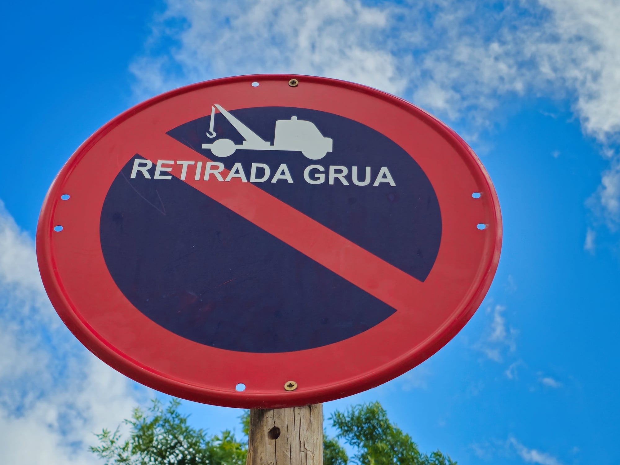 Señal de tráfico de prohibido aparcar y aviso de retirada por la grúa
