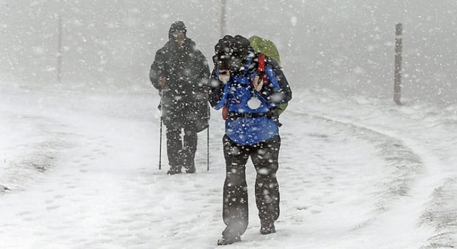 Dos peregrinos en el Camino de Santiago en la provincia de Navarra, en una jornada en la que se han visto sorprendidos por el fuerte temporal de viento y nieve