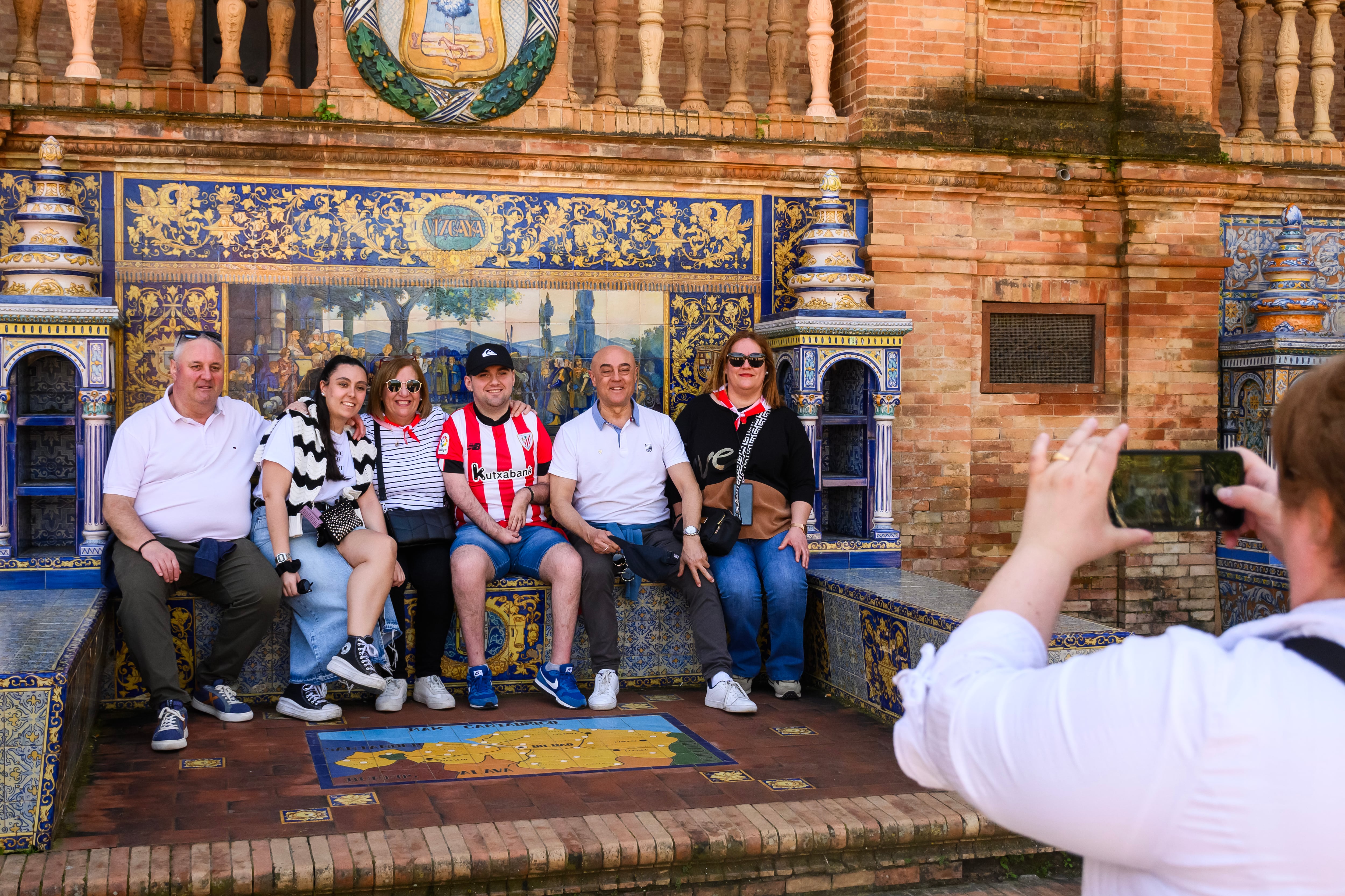 GRAFAND297. SEVILLA, 04/04/2024.-Aficionados del Athletic Club de Bilbao se hacen una fotografía en el azulejo de Vizcaya de la Plaza de España de Sevilla este jueves antes del encuentro de la final de la Copa del Rey que su equipo disputará el próximo sábado contra el Real Club Deportivo Mallorca en el estadio de La Cartuja de la capital andaluza. EFE/ Raúl Caro.
