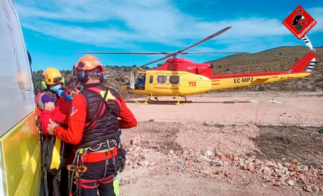 La mujer que sufrió el desmayo en el momento de subir a la ambulancia con el helicóptero al fondo