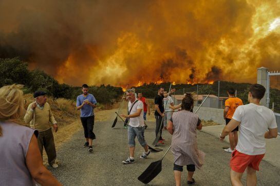 GRA229 CUALEDRO (OURENSE), 30/08/2015.- En la imagen, un grupo de vecinos de la localidad de Cabreiro ante las llamas del incendio forestal de Cualedro (Ourense) que ha arrasado ya 1.300 hectáreas.-EFE//Brais Lorenzo