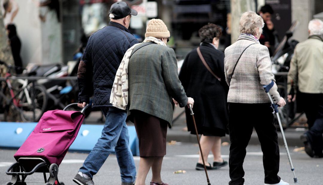 Varias personas de la tercera edad cruzan un paso para peatones