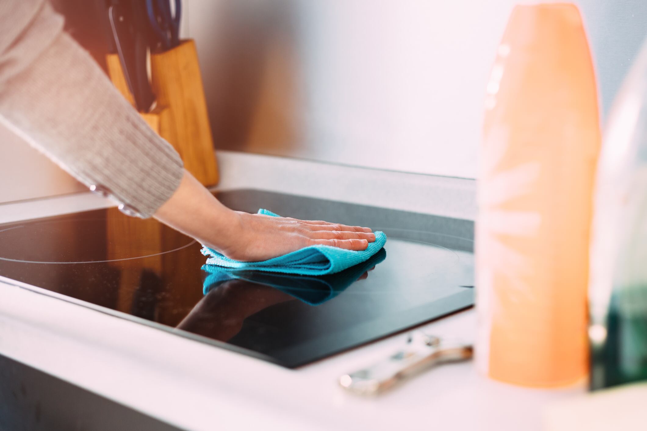 Una mujer limpiando una cocina vitrocerámica