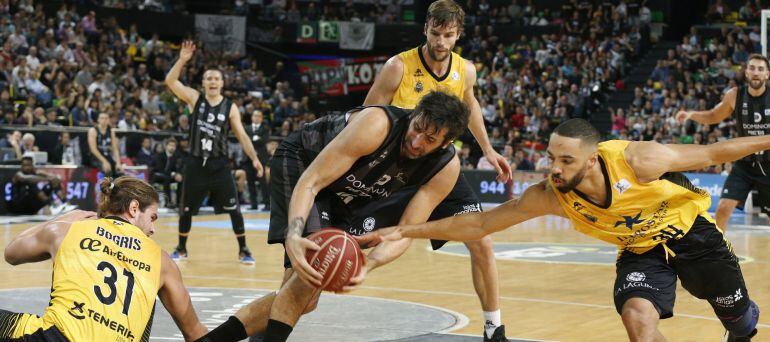 El jugador del Retabet Bilbao Basket Alex Mumbrú (c) disputa un balón con el jugador del Iberostar Tenerife Davin White (d) en el partido correspondiente a la liga Endesa disputado en el BilbaoArena