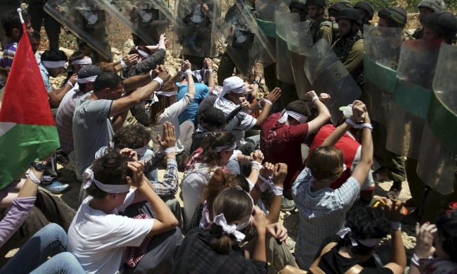 Palestinos se enfrentan a soldados israelíes durante la celebración de una protesta contra la expasión de asentamientos judios