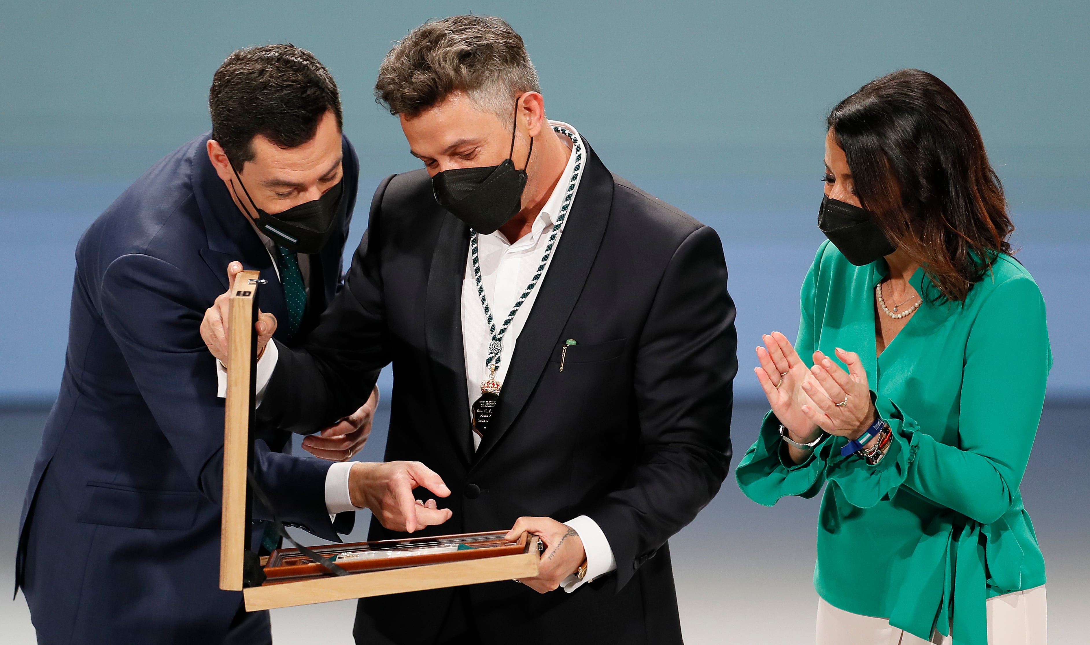 SEVILLA, 28/02/2022.- El presidente de la Junta de Andalucía, Juanma Moreno y la presidenta del Parlamento de Andalucía, Marta Bosquet hacen entrega de la distinción de hijo predilecto al cantante, Alejandro Sanz durante la ceremonia de entrega de medallas del Día de Andalucía celebrado en el teatro de la maestranza de Sevilla. EFE/José Manuel Vidal
