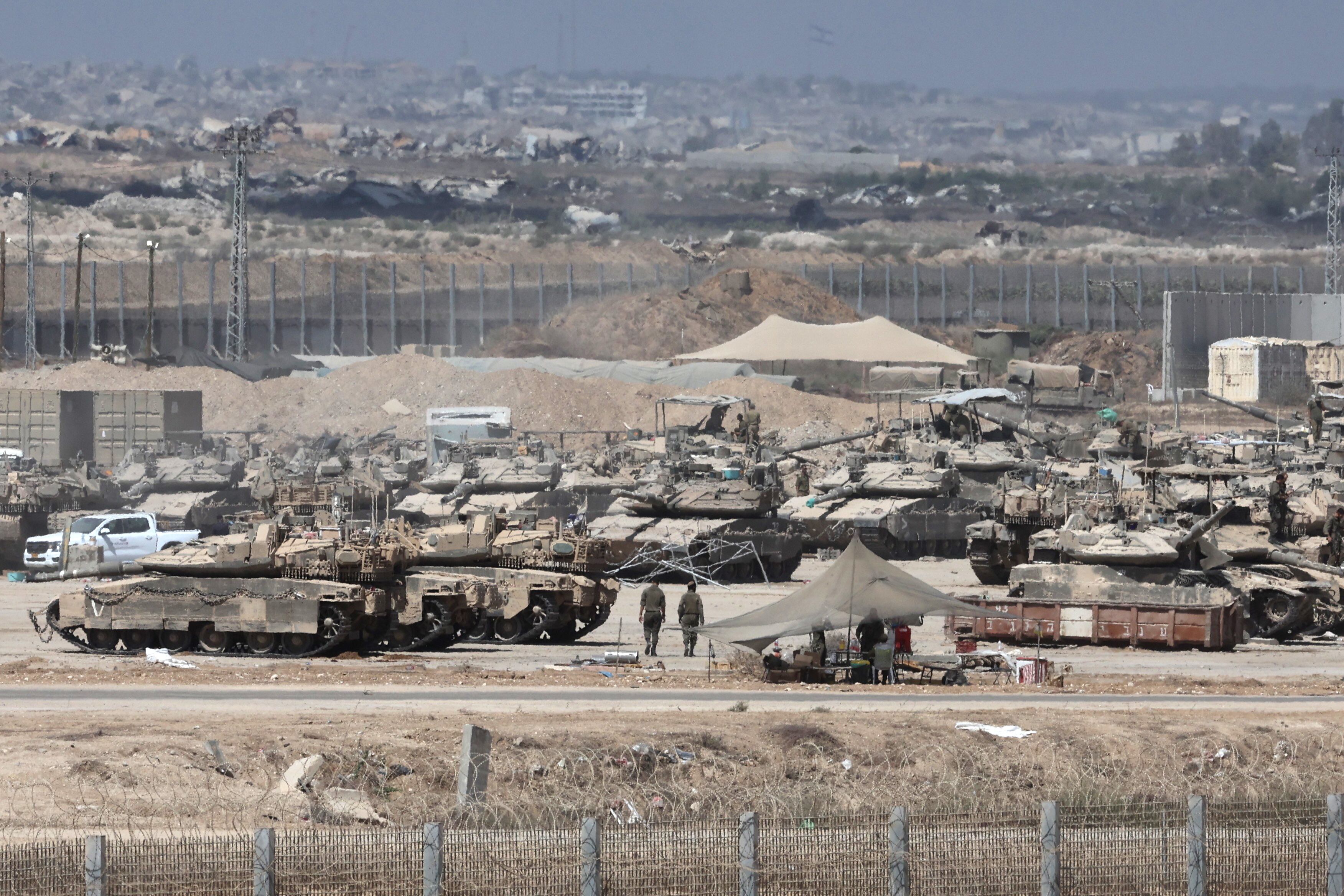 Soldados israelíes con vehículos militares se reúnen cerca de la valla fronteriza con la Franja de Gaza, visto desde el lado israelí de la frontera, este martes. 