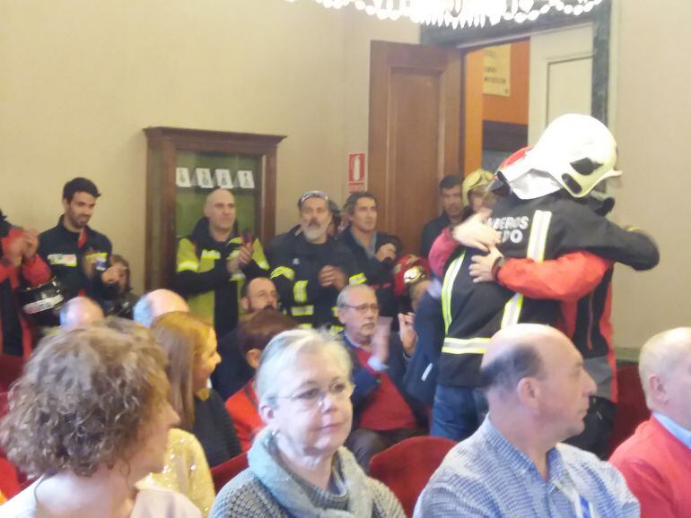El bombero Juan Carlos Fernández Granda 'Cuni', compañero del fallecido Eloy Palacio, se abraza a otro bombero tras su intervención en el Pleno del Ayuntamiento de Oviedo.