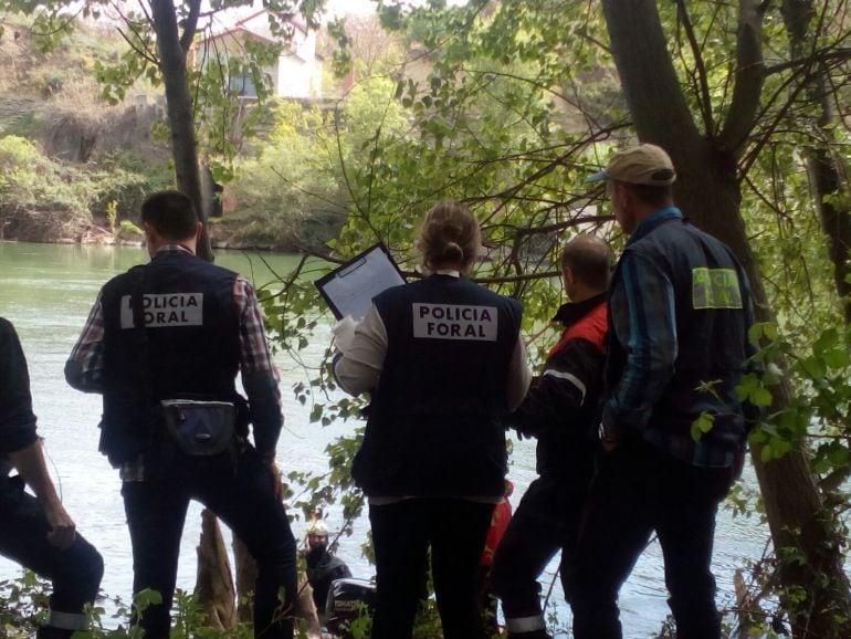 Efectivos de Policía Foral y de bomberos intervienen en la extracción del cadáver en el río Ebro en Sartaguda.