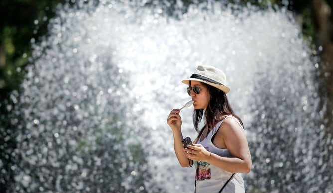 Una mujer disfruta de un helado en el parque del Oeste para mitigar el calor de Madrid