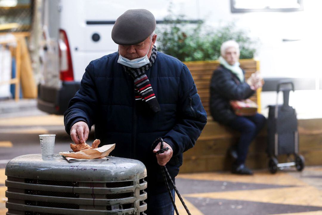 Un hombre desayuna en una calle del centro de Barcelona