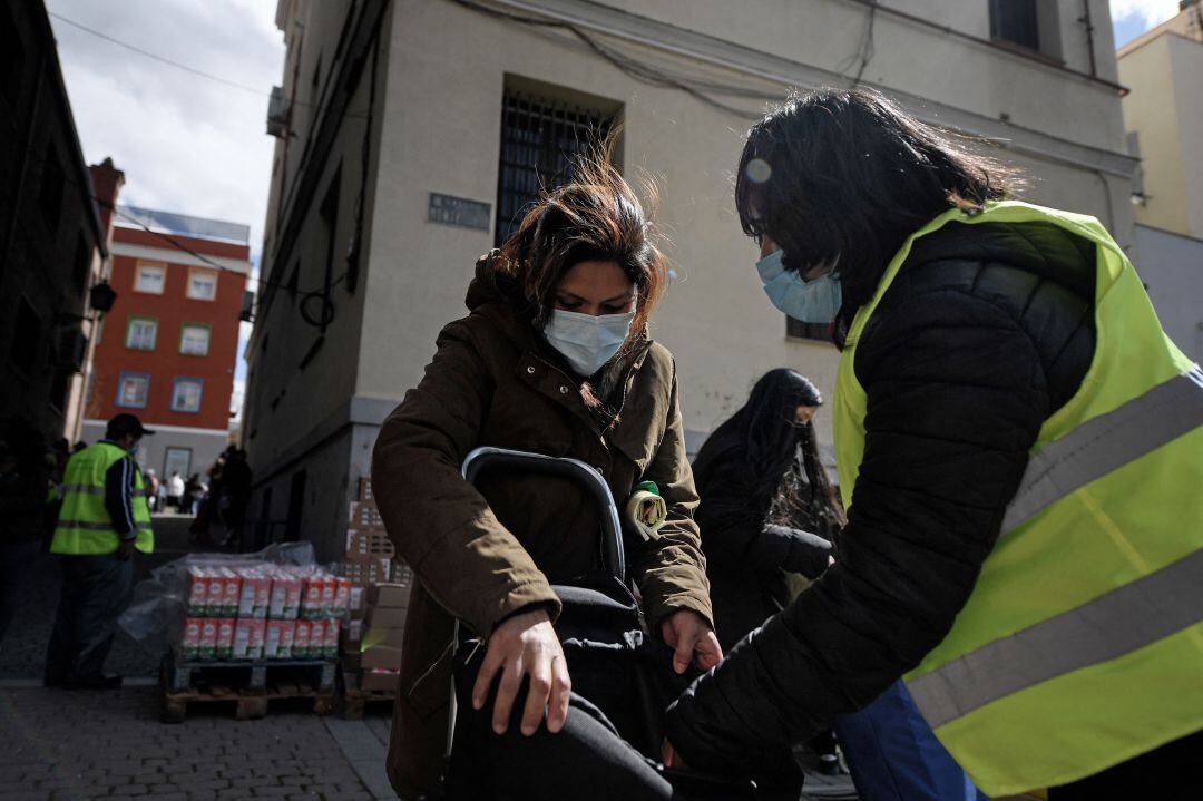 Reina Chambi, de 39 años, recoge comida en la Iglesia de San Ramón Nonato.