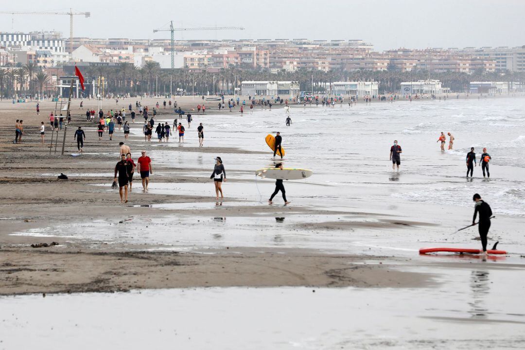 Cientos de personas pasean, durante la franja horaria permitida, en la playa de la Malvarrosa, en Valencia, hoy quincuagésimo sexto día del estado de alarma