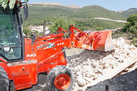 Máquinas excavadoras se cruzan con camiones que traen los materiales, alimentos y artículos de primera necesidad para la población