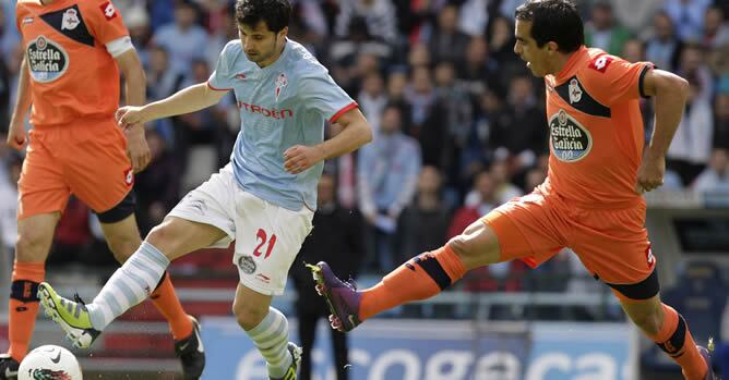 El jugador del Celta de Vigo Álex López pugna por el balón con el defensa paraguayo del Deportivo de la Coruña Claudio Morel durante el partido