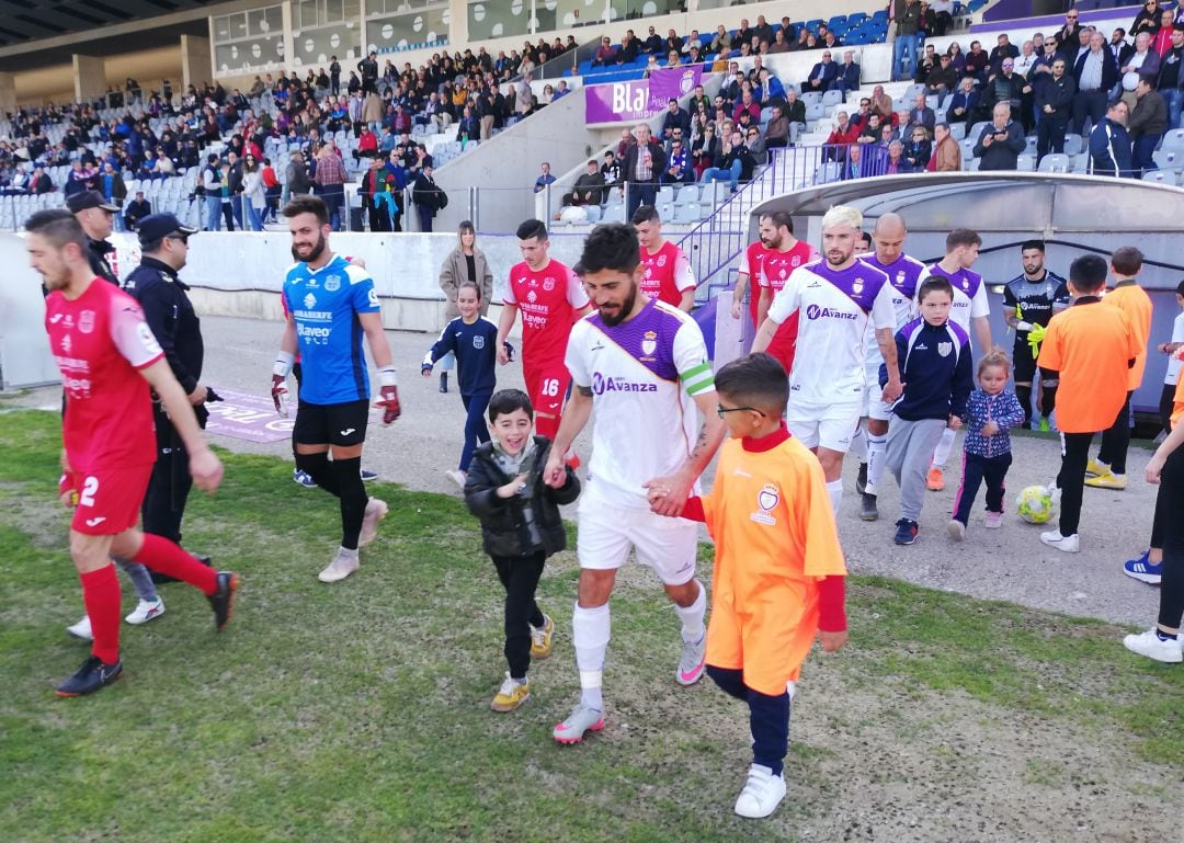 Jugadores de Real Jaén y Torreperogil saliendo al campo de La Victoria.