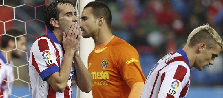 GRA234. MADRID, 14/12/2014.- Los jugadores del Atlético de Madrid, el uruguayo Diego Godín (i) y el francés Antoine Griezmann (d), junto al portero Sergio Asenjo (c), del Villarreal, durante el partido de la decimoquinta jornada de Liga en Primera Divisió
