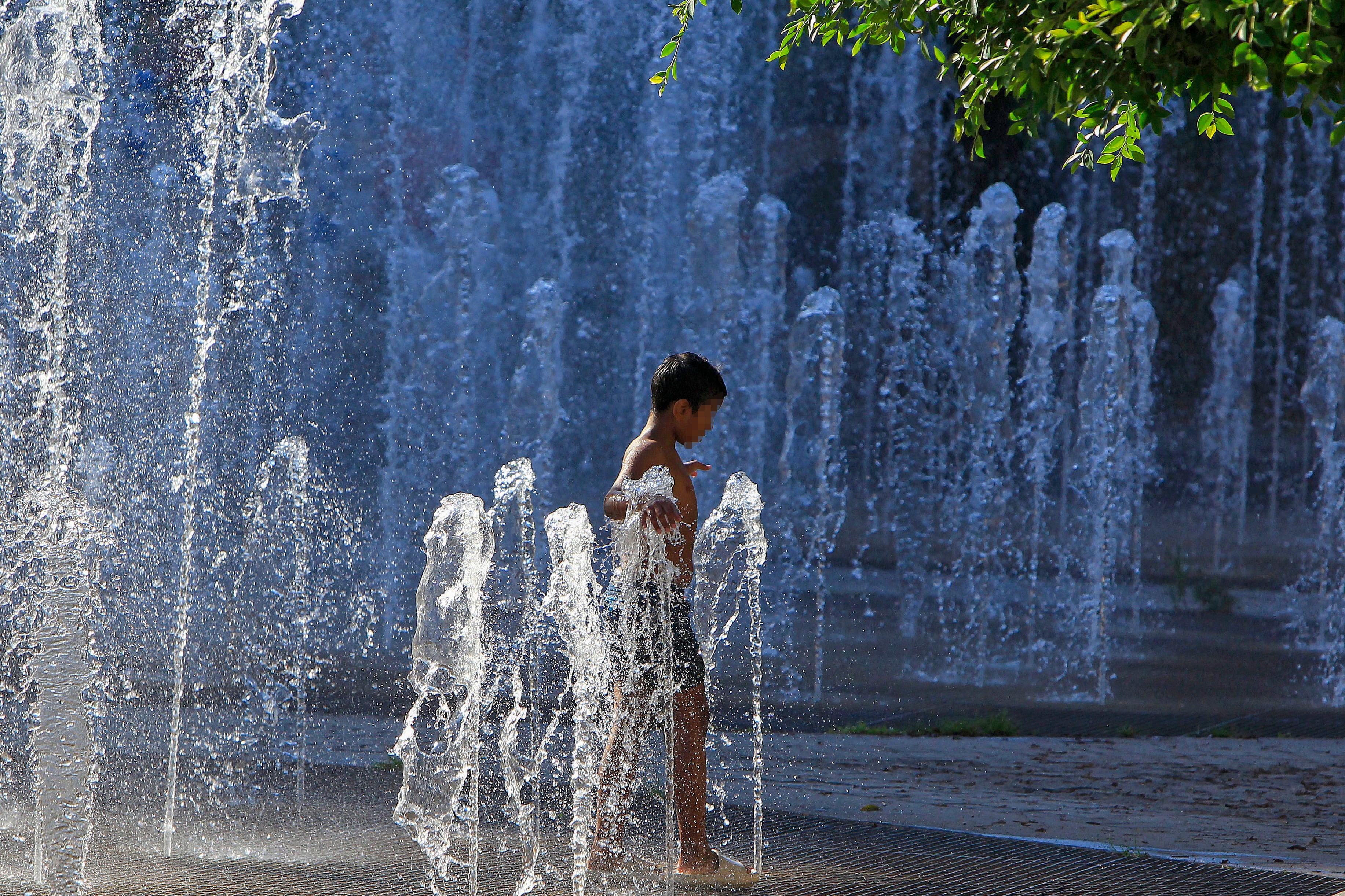 Un niño se refresca en la fuente de la plaza de España de Alicante en la segunda ola de calor de este verano la pasada semana. EFE/Morell