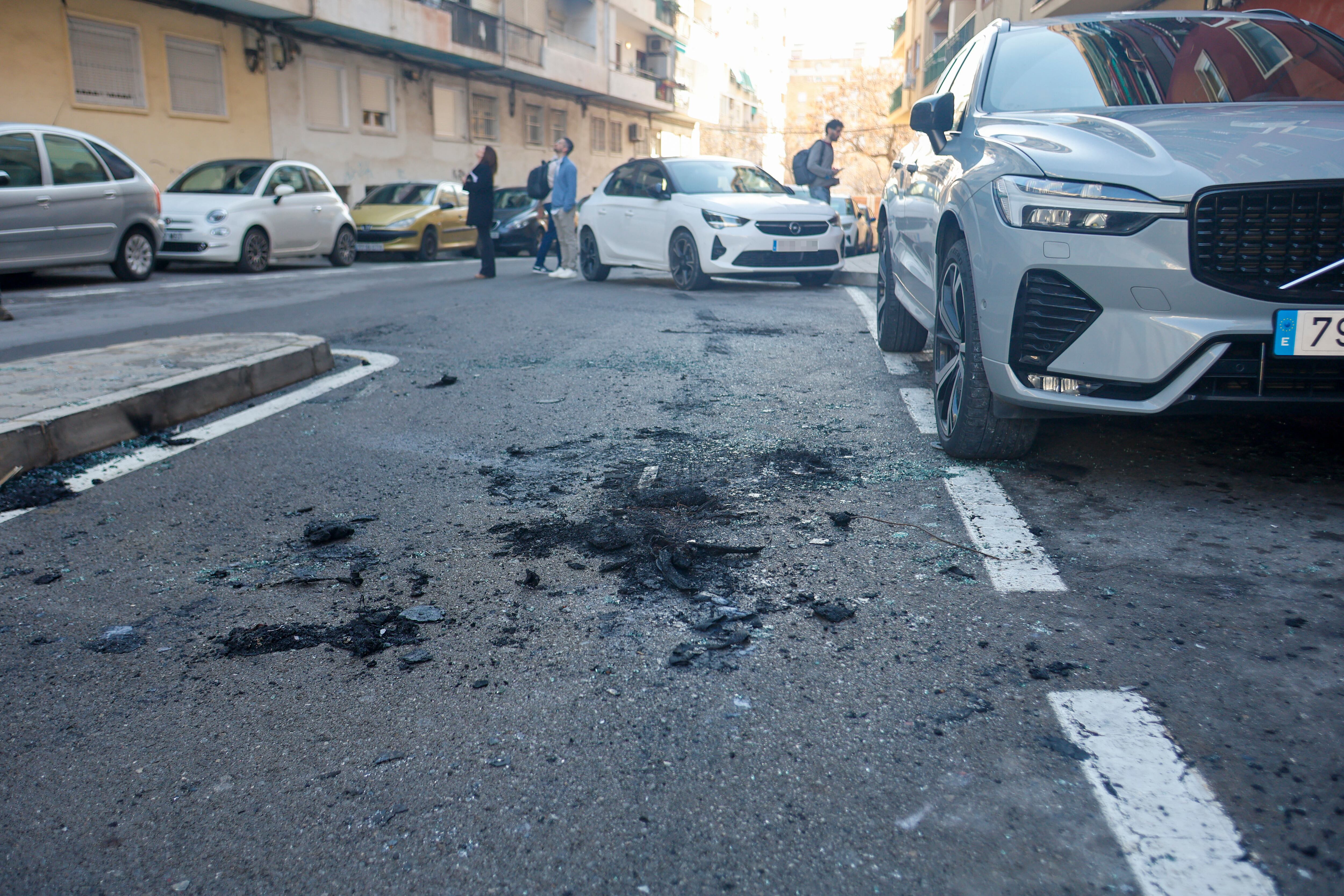 GRAFCVA2633. ALICANTE, 12/03/2026.- Restos de un vehículo calcinado en las inmediaciones de la vivienda y sobre la misma hora en la que un hombre resulto muerto ayer por un disparo cuando se encontraba en el balcón de su casa en un barrio del centro de la ciudad de Alicante. EFE/Morell