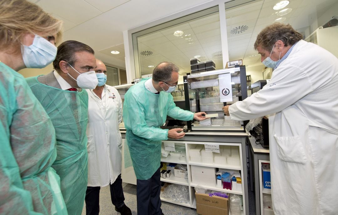 El Consejero de Salud, Pablo Fernández Muñiz, visita el Laboratorio de Virología del Hospital Universitario Central de Asturias, acompañado por el director territorial de Asturias y Cantabria del Banco Santander, Manuel Iturbe, para conocer el robot covid que ha donado la entidad bancaria junto a 178.000 test rápidos