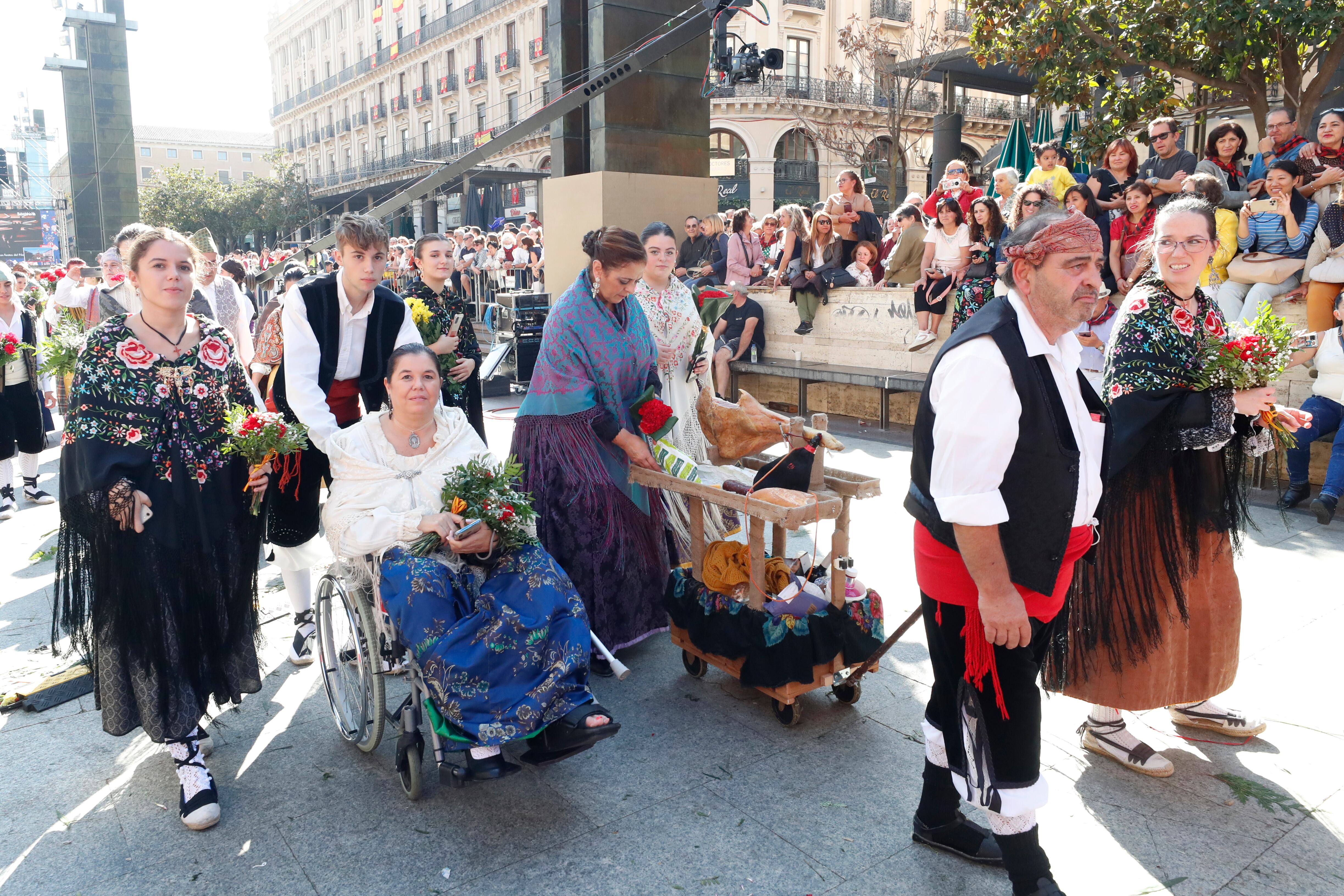 ZARAGOZA, 12/10/2022.- Varias personas participan en la ofrenda a la imagen de la Virgen del Pilar, este miércoles en el centro de la plaza de Zaragoza que lleva su nombre, una ofrenda llena de ilusión que se espera de récord tras dos años de pandemia, con más grupos inscritos que en 2019 y la previsión de alcanzar alrededor de siete millones de flores. EFE/ Javier Cebollada
