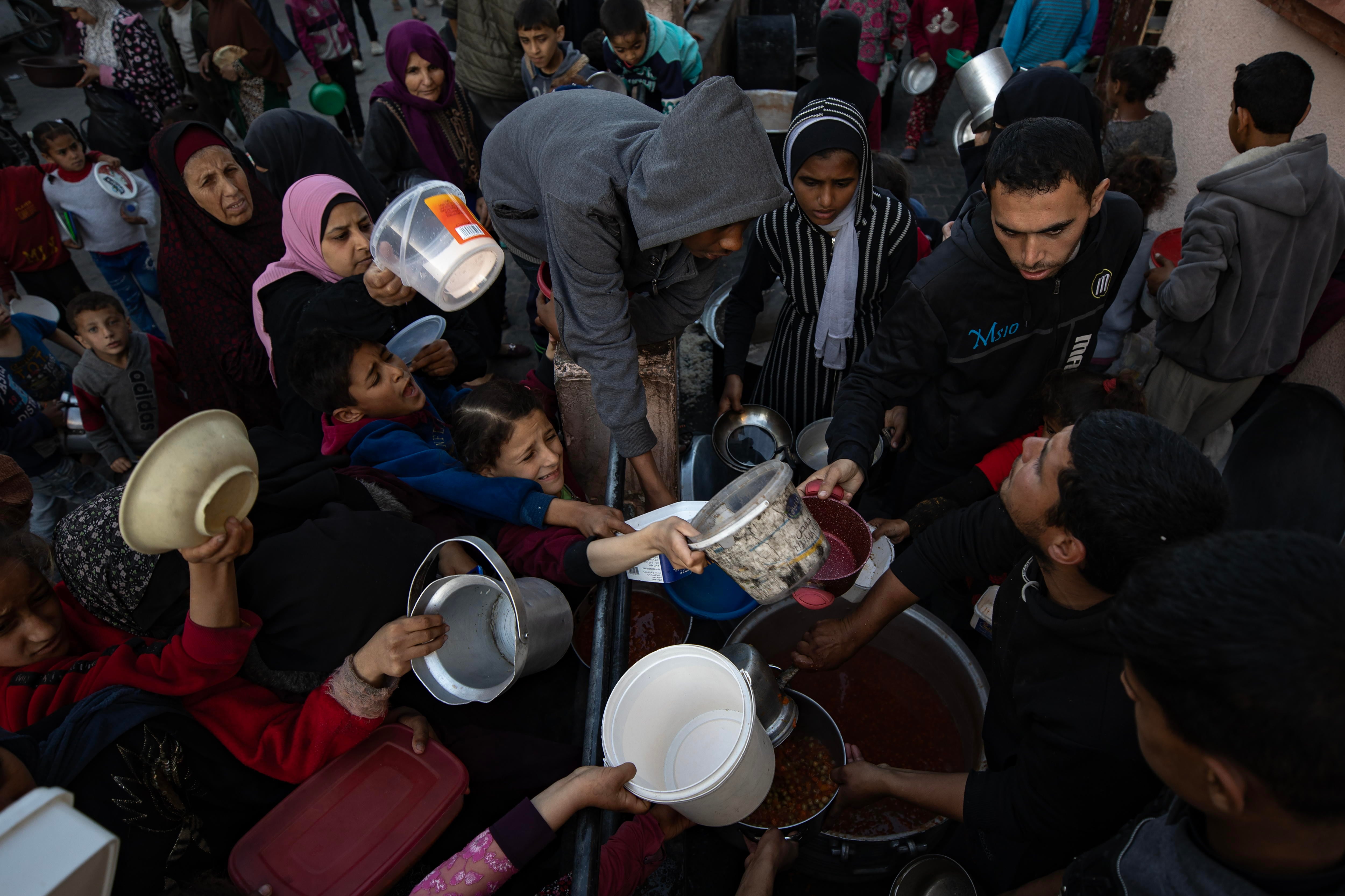 Palestinos intentando conseguir alimento en Rafah.