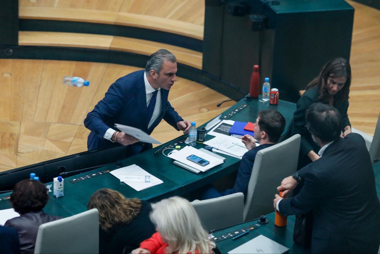 Momento exacto en el que Javier Ortega Smith tira la botella de agua de la mesa del concejal Eduardo Rubiño